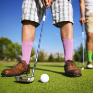 A man prepares to sink his putt.