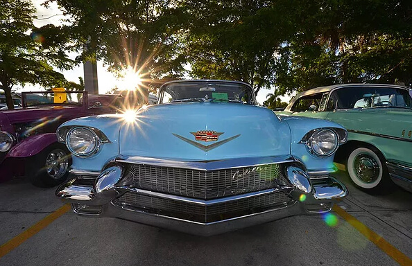 An blue antique Cadillac is on display with other cars at a Fort Myers Beach car show.