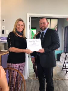 Lee County Sheriff Ryan Justham receives the FMB Chamber Deputy of the Month award from Jacki Liszak.