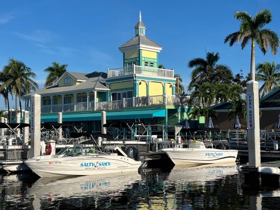Salty Sam's Rental Boats docked at fuel dock with tropical building and palm trees in background